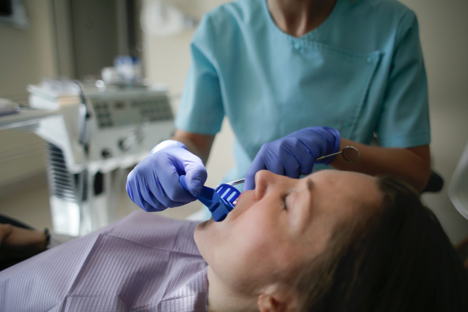 A dental assistant taking a dental impression of a patient&rsquo;s mouth