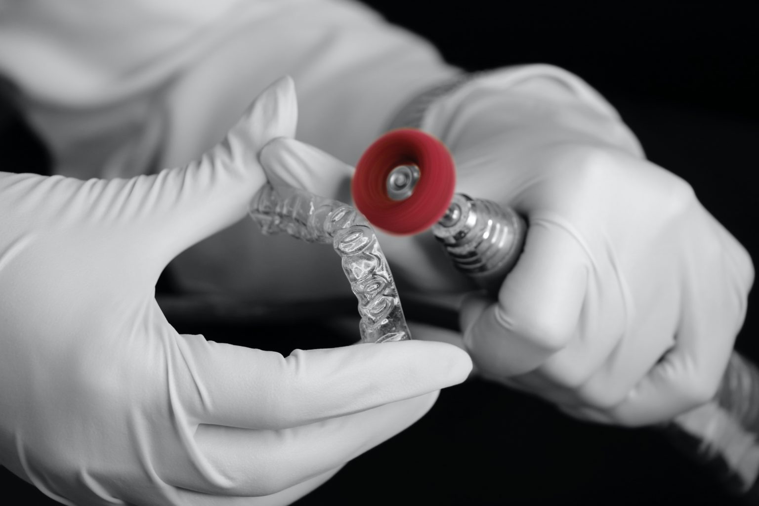 A gloved hand making a clear aligner
