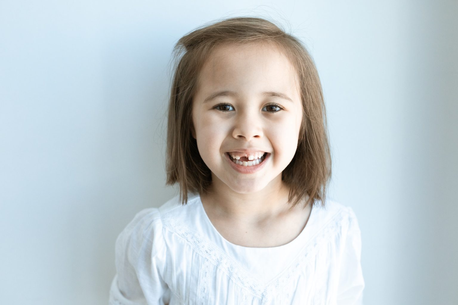 A girl with a lost tooth smiling