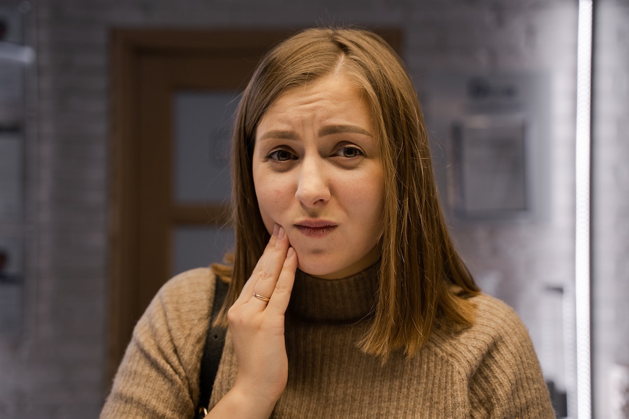 A woman with toothache holding her cheek