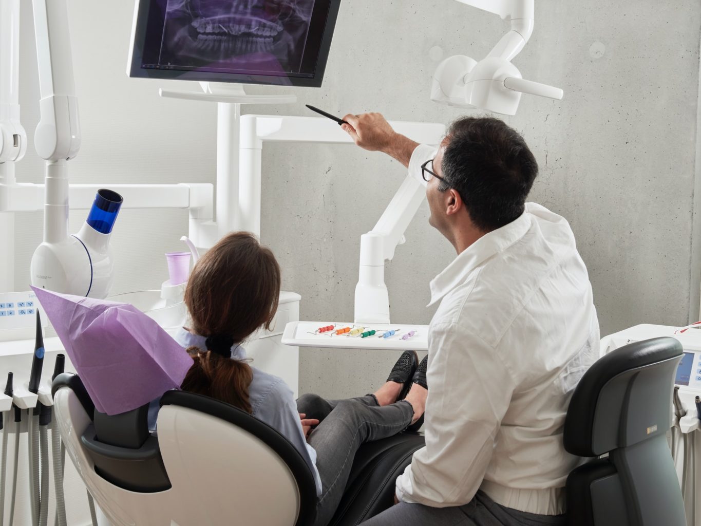 dentist explaining x-ray results to patient in exam room