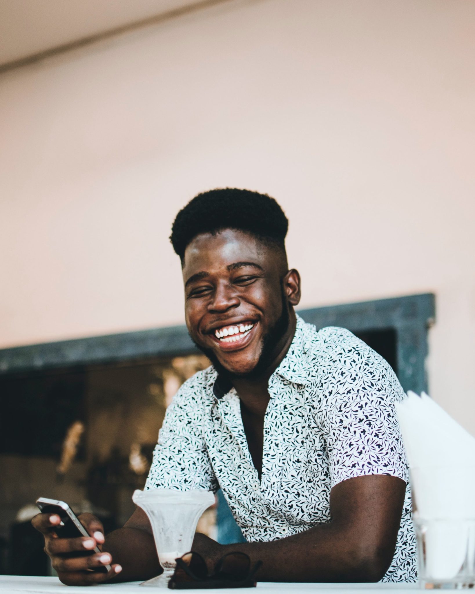 Man grinning while holding a phone.