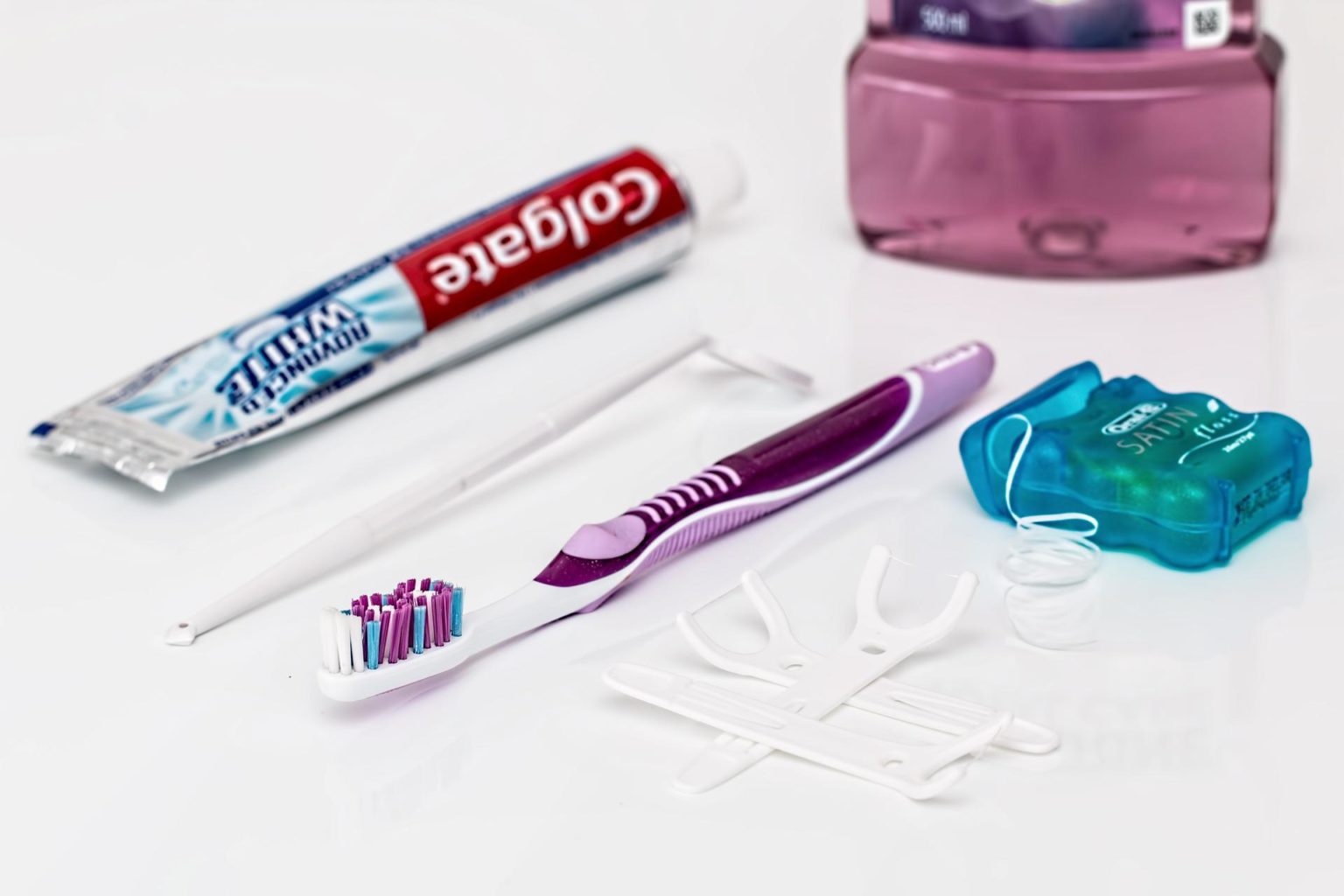 A toothbrush with floss on a white surface