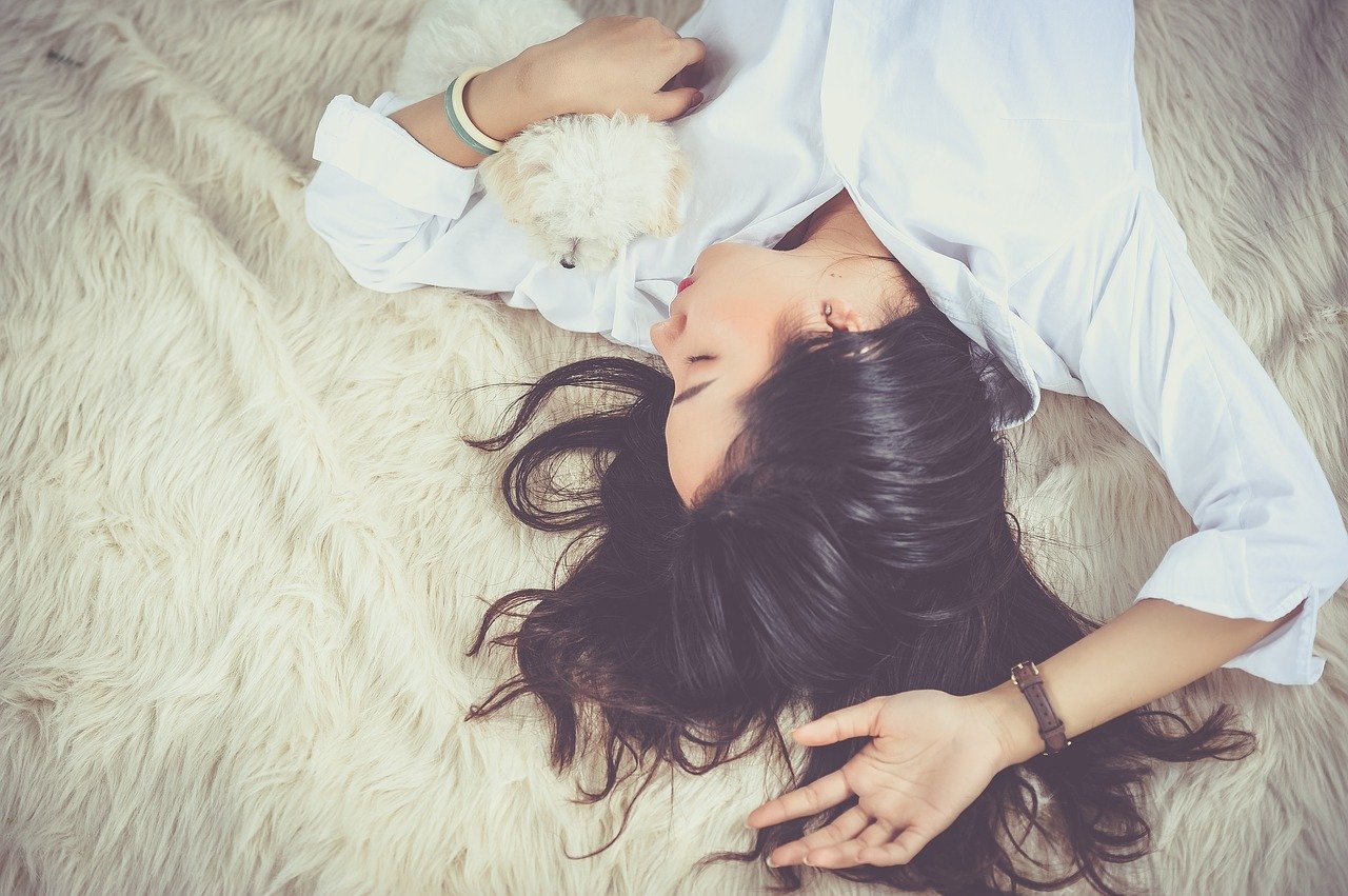 A woman sleeping beside a dog