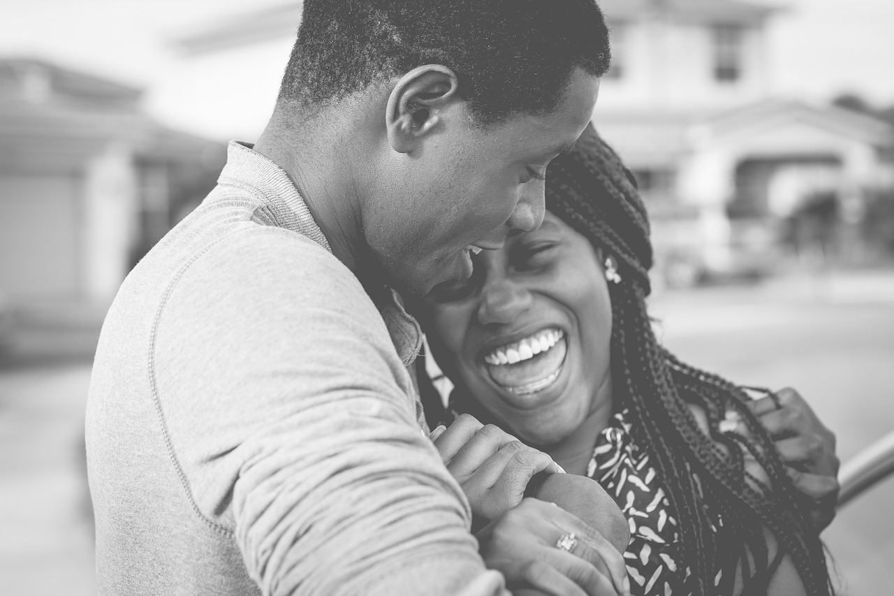 A woman smiling in a man’s arms after teeth whitening