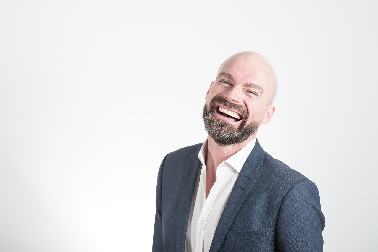 man in suit smiling with teeth showing