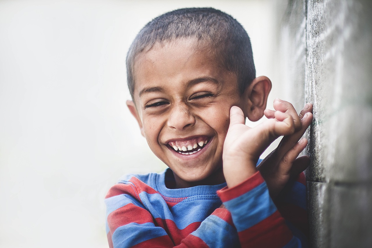 A young boy smiling with eyes closed