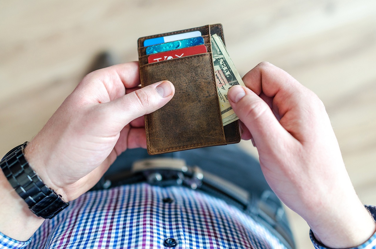man holding wallet with cards and money