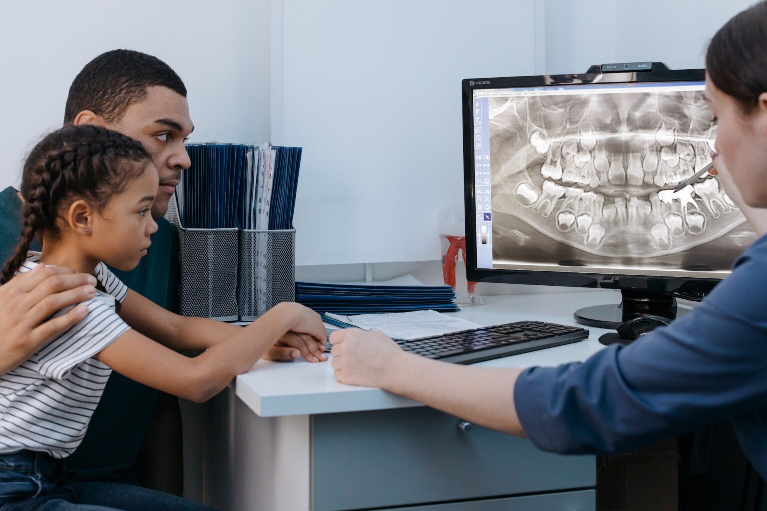 A man and child looking at a dental X-ray with a dentist