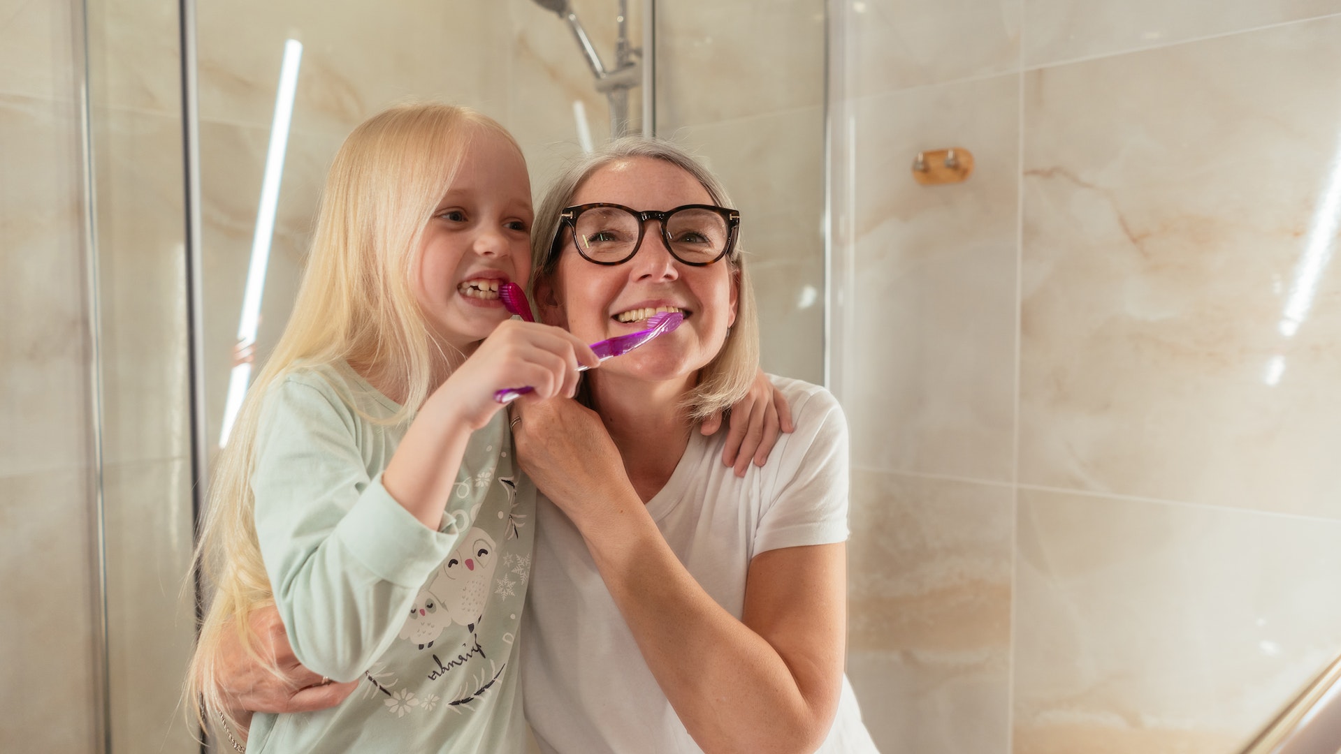 A woman and a child brushing their teeth