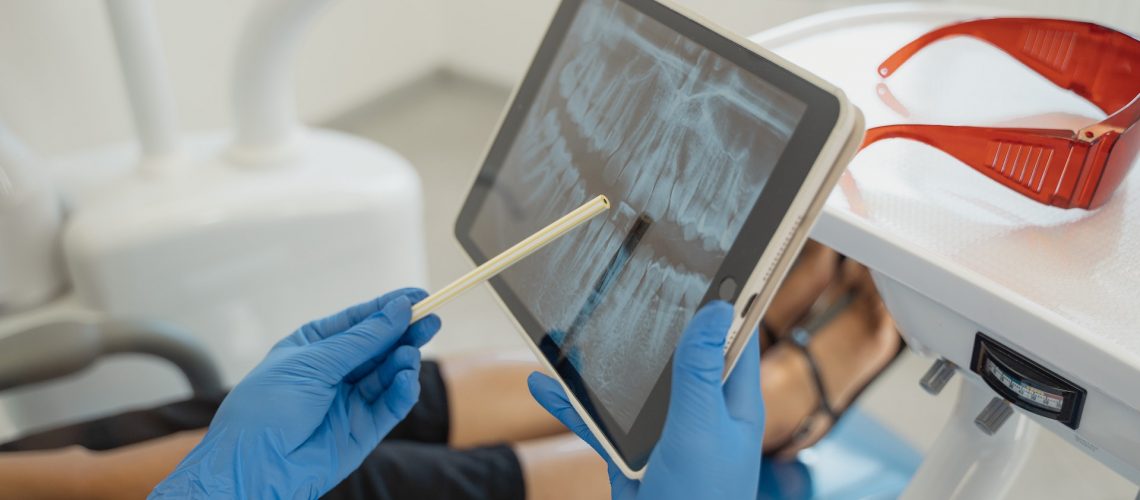 A dentist showing a digital X-ray to a patient
