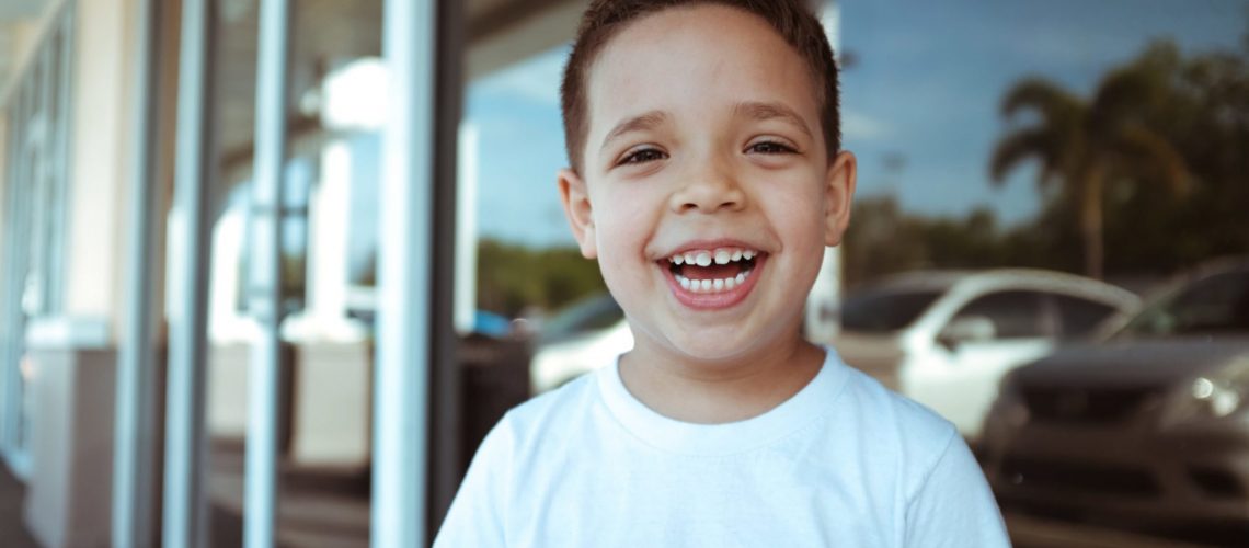 A boy with a loose tooth smiles