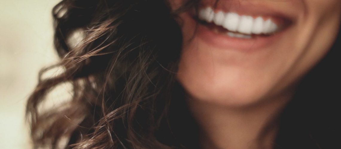 A young woman smiling and revealing perfect teeth