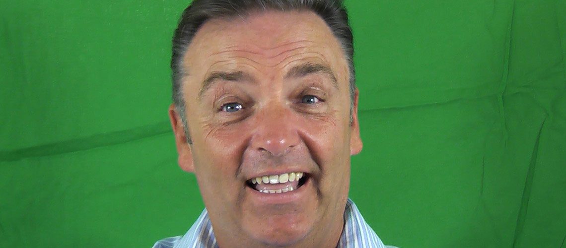 man smiling in front of green screen