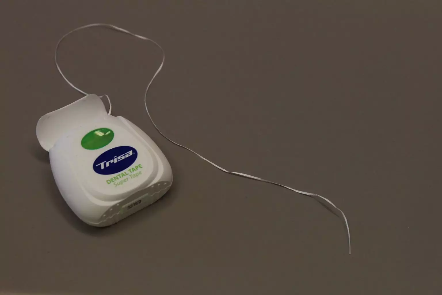 floss container on a gray surface